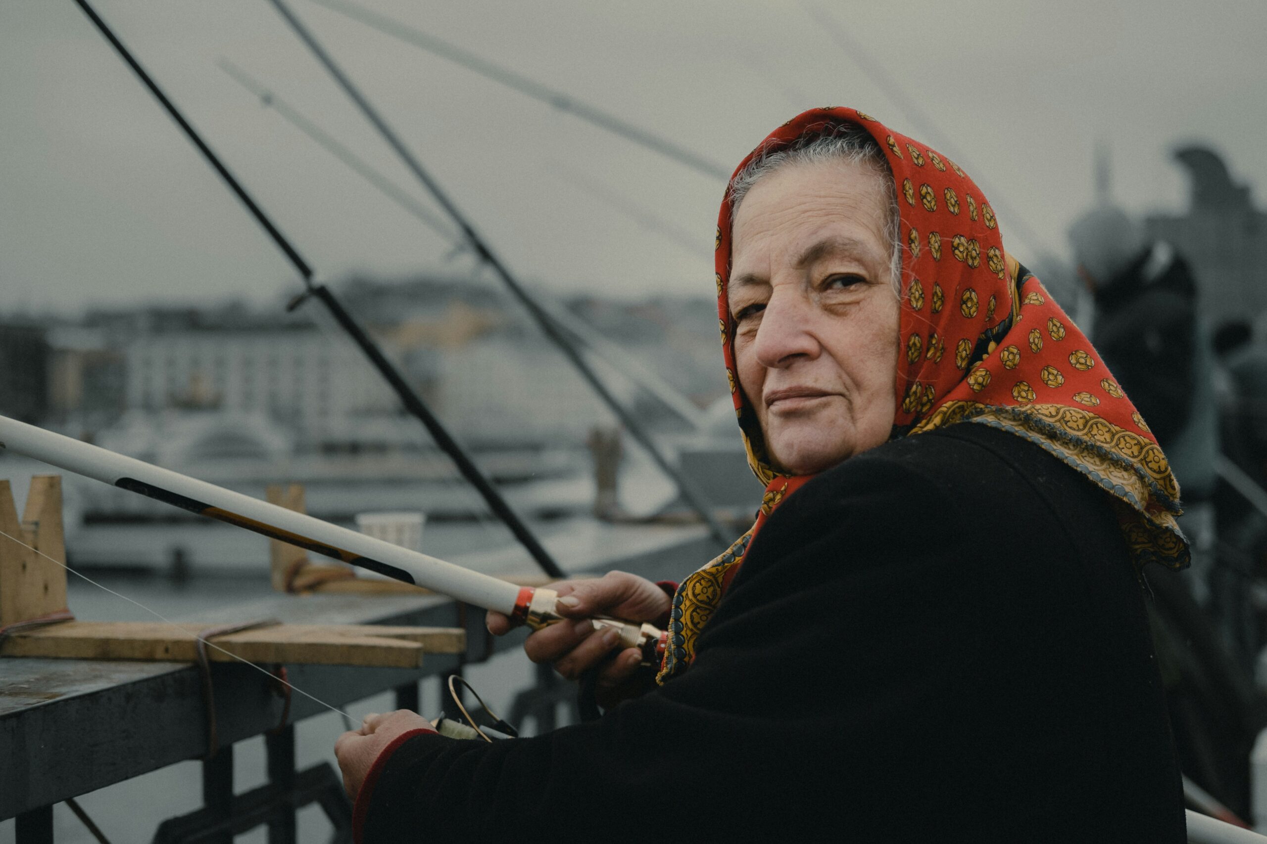 woman fishing on bridge during daytime